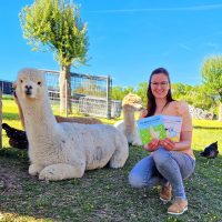 Elisabeth Gottschall mit ihren Alpaka-Kinderbüchern auf der Alpakaweide